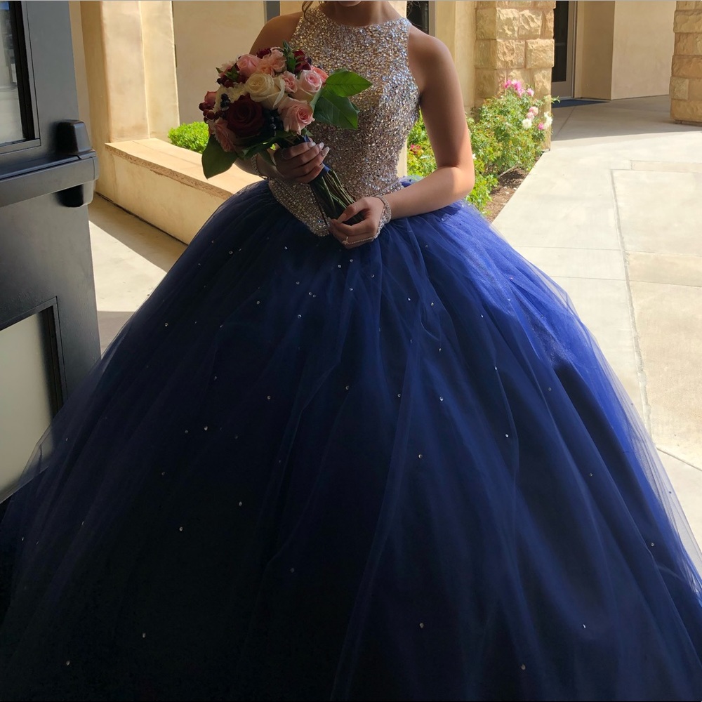Navy blue quinceneara dress with bedazzled top with open back.